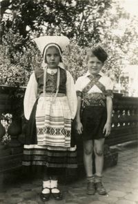 Girl and boy in costume on porch of Main Library