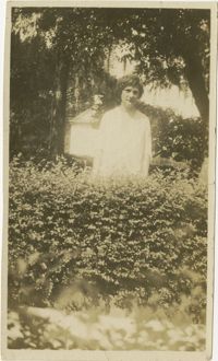 Woman Standing Behind Bushes