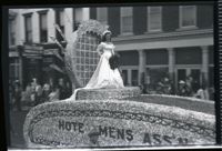 Woman in a Dress Holding Flowers on a Parade Float