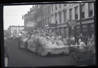 Women in Dresses Holding Flowers on a Parade Float