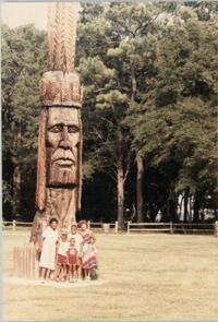 Photograph of a Family Standing Beside a Wooden Sculpture