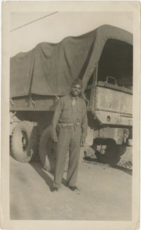Photo of an African American Man Posing Next to a Military Truck
