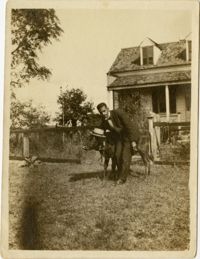 Herbert U. Seabrook, Sr. standing in yard beside a cow