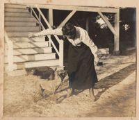 Woman playing with dogs in front of Halls Island house