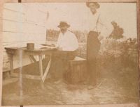 Leonard Donner at table outside; unidentified man beside him