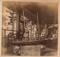 Model boat with mast near rocking chairs