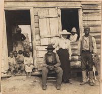 Pauline Donner with group of African Americans outside cabin