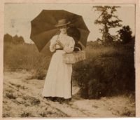 Portrait of woman with opened umbrella and basket
