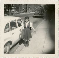 Unidentified girl, standing beside car
