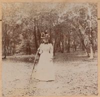 Unidentified woman with walking stick in woodland setting