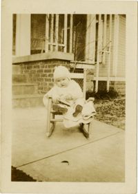 Infant sitting rocking chair outside