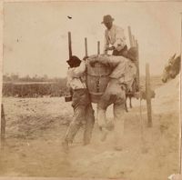 Men struggle with barrel full of harvested potatoes