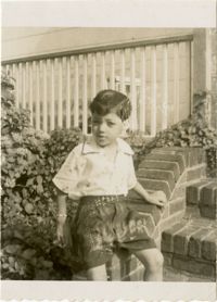 Unidentified boy seated on a porch step